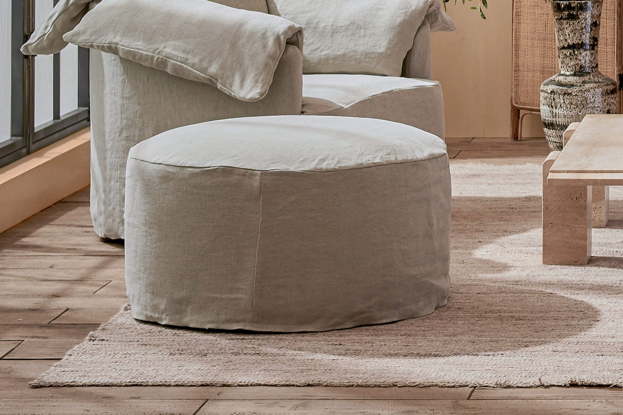 Loula chair ottoman in Jasmine Rice, a light warm greige Medium Weight Linen, placed next to Loula Chair