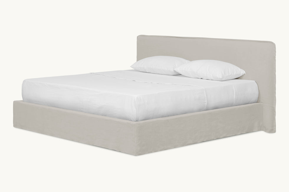 Angled view of Neva King Bed in Jasmine Rice, a light warm greige Medium Weight Linen