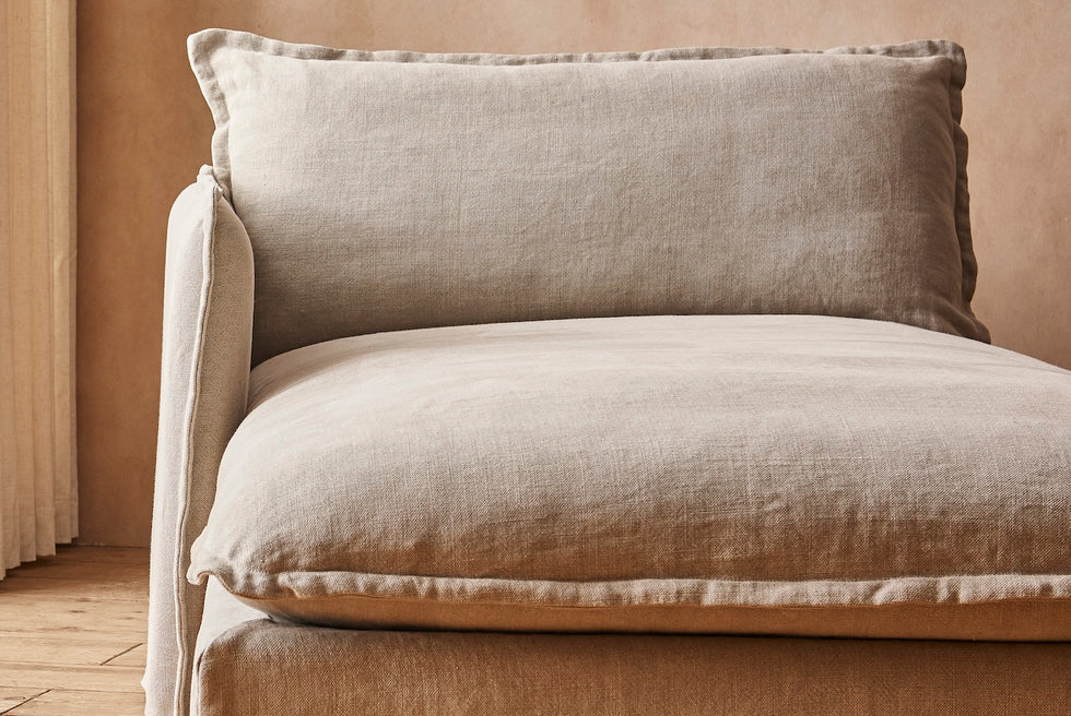 Close up of Neva Left Arm Facing Daybed in Jasmine Rice, a light warm greige Medium Weight Linen, in a warmly lit room