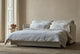 Slide #3 Neva Sleeper Sofa in Young Coconut, a powdery white Recycled Poly Linen, pulled out and made up with white linen bedding