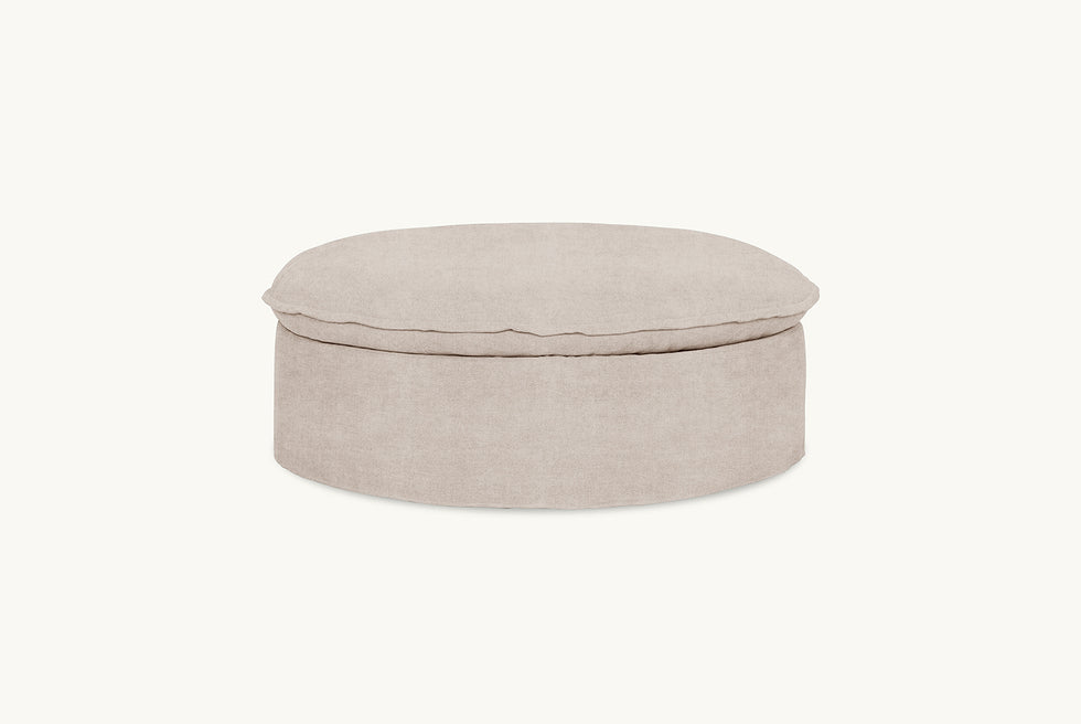 Front view of Neva Round Storage Ottoman in Oat Flour, a medium taupe Light Weight Linen