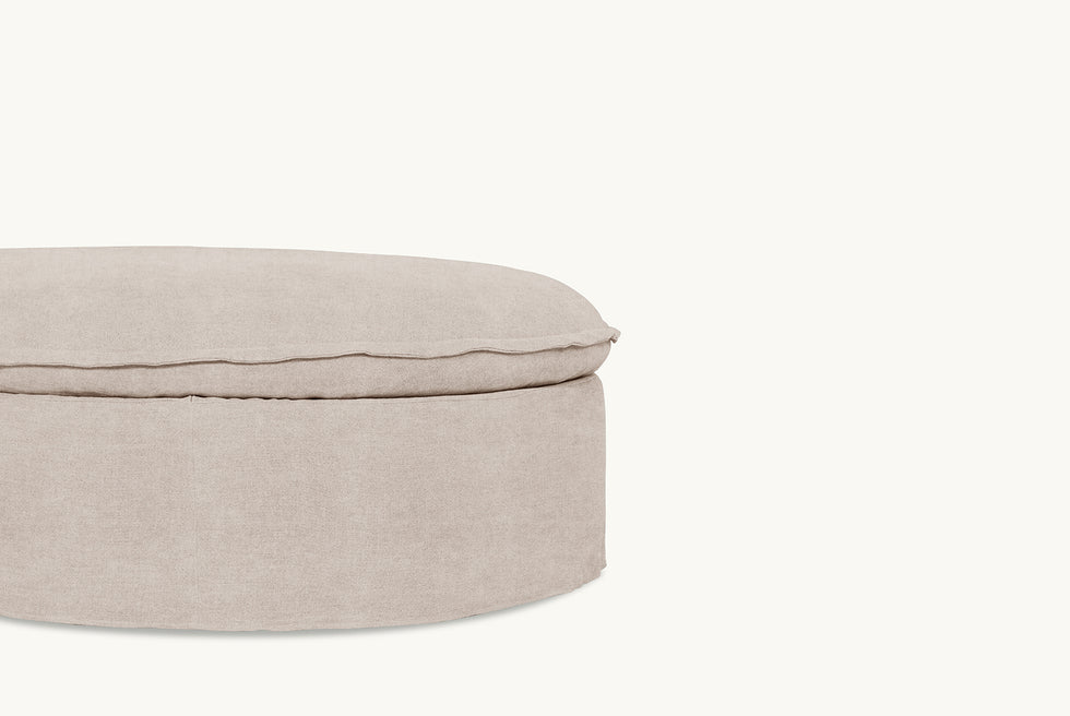 Close up of Neva Round Storage Ottoman in Oat Flour, a medium taupe Light Weight Linen