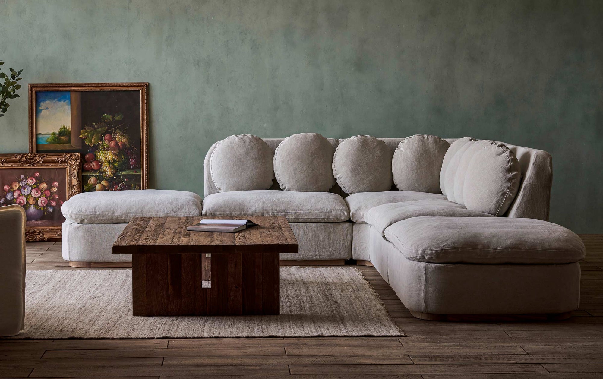 Olea Long Corner Sectional Sofa in Jasmine Rice, a light warm greige Medium Weight Linen placed around a Kai Coffee Table