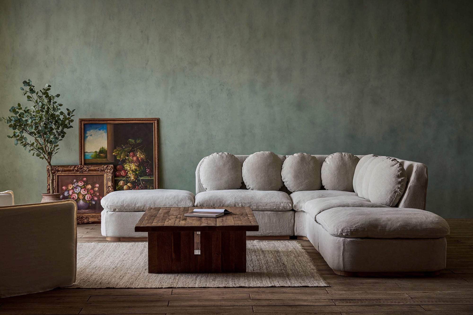 Olea Long Corner Sectional Sofa in Jasmine Rice, a light warm greige Medium Weight Linen, placed in a room facing a coffee table
