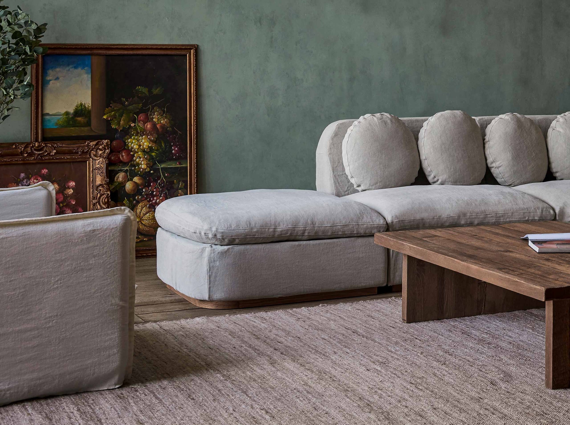 Olea Sectional Ottoman in Jasmine Rice, a light warm greige Medium Weight Linen, placed with the Olea Sectional and a Kai Coffee Table