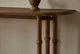 Slide #7 Close up of Pia Console Table in 100% Reclaimed Chinese Heritage Pine, a medium, bosc pear shade with earthy undertones, decorated with a stone vase