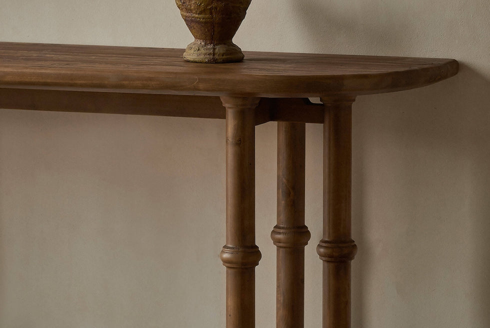 Close up of Pia Console Table in 100% Reclaimed Chinese Heritage Pine, a medium, bosc pear shade with earthy undertones, decorated with a stone vase