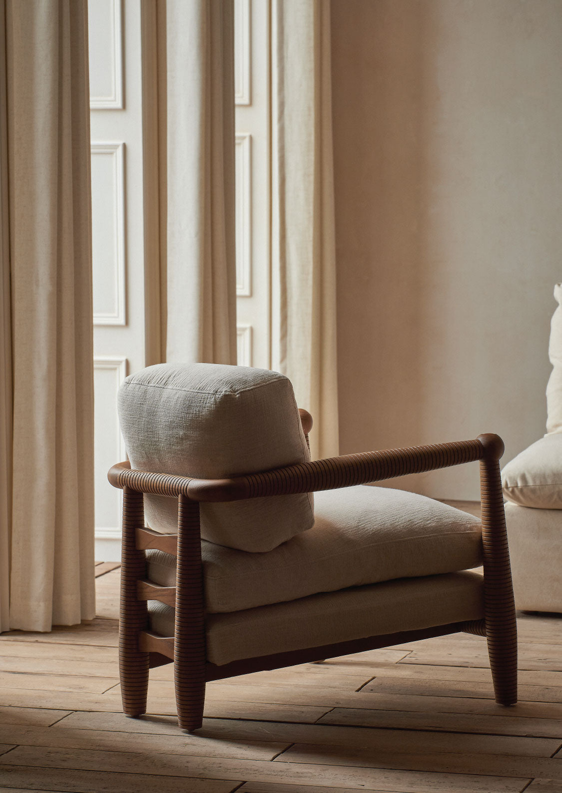 sixpenny Gio chair with cushions in a softly lit room