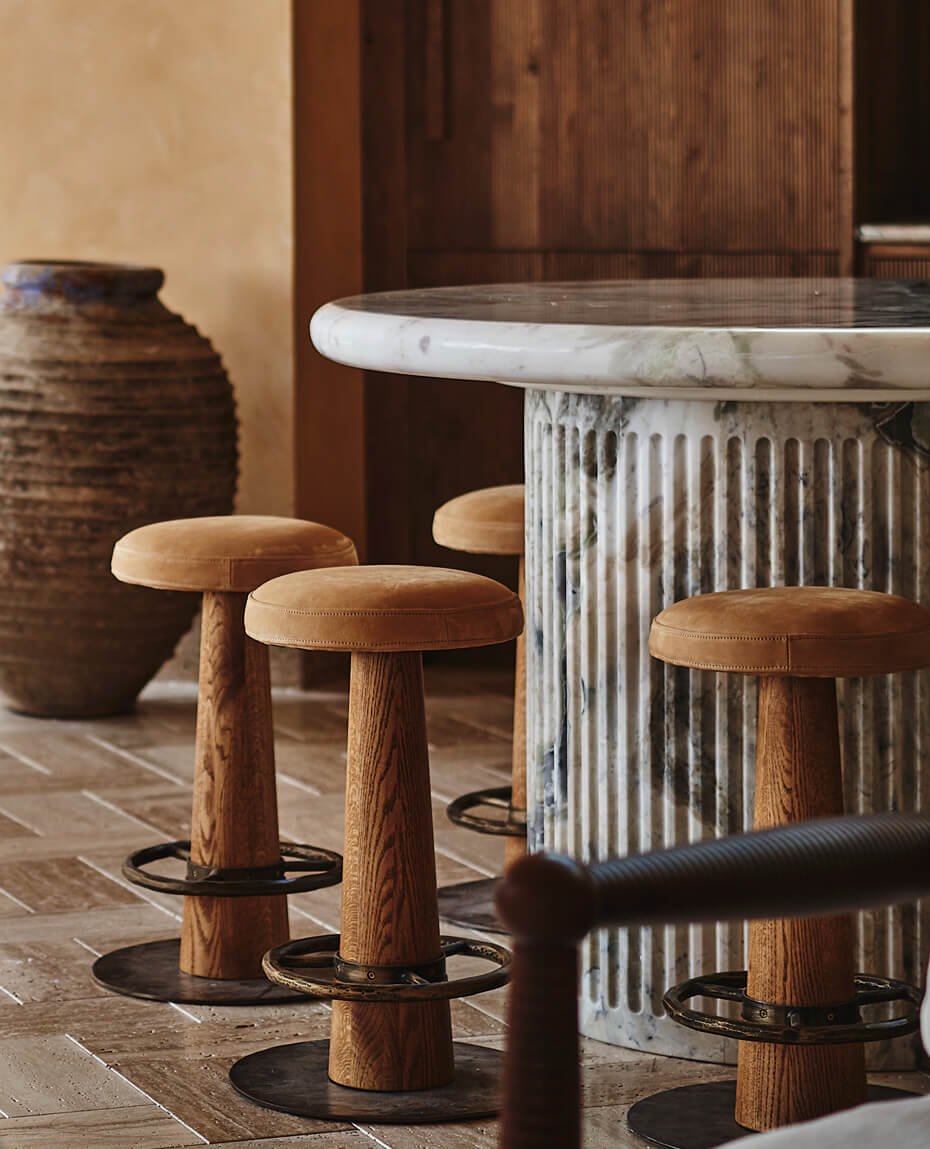 Custom barstools placed around a custom marble dining table at the Sixpenny Loft