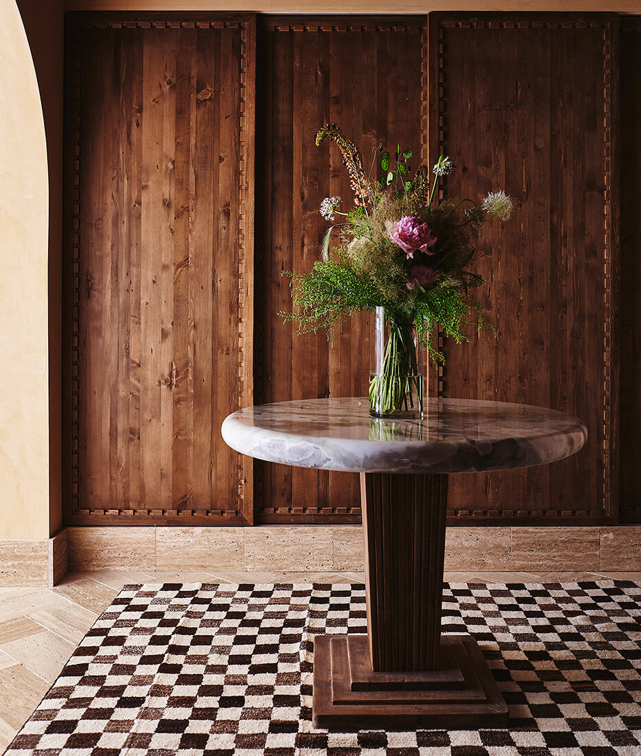 Flowers in a vase on top of a custom Wood and Marble table