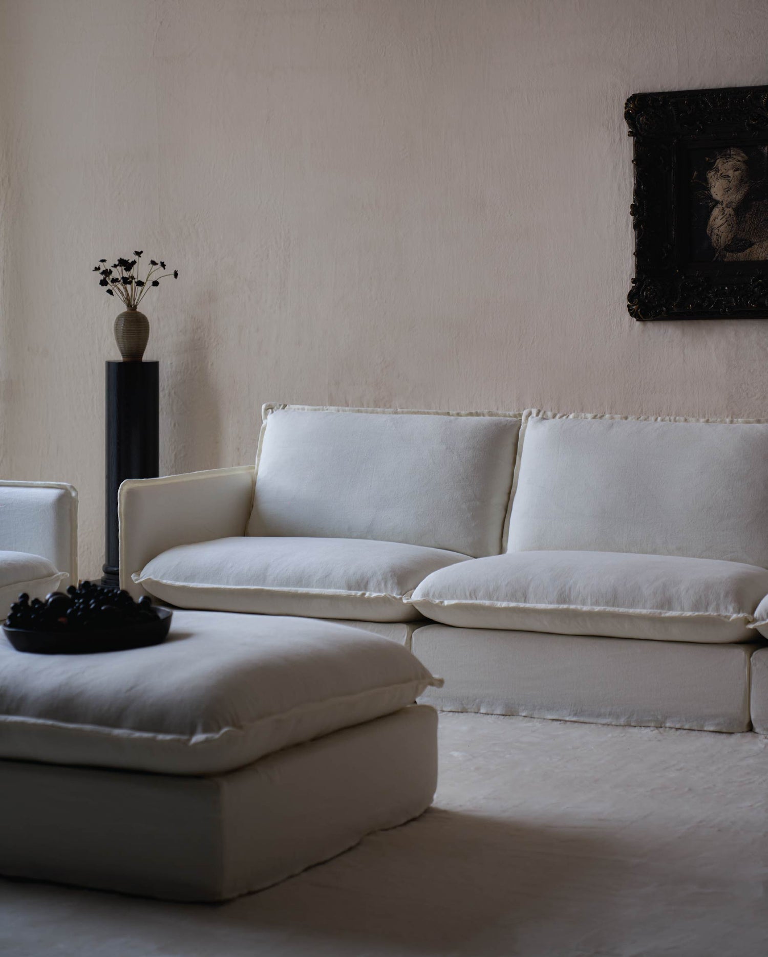 sixpenny neva sofa in a room with a neutral wall and decorative elements.