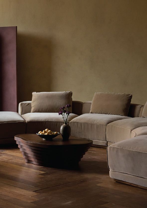 living room with sixpenny yogi half-moon sectional sofa, tera coffee table, and decorative elements.