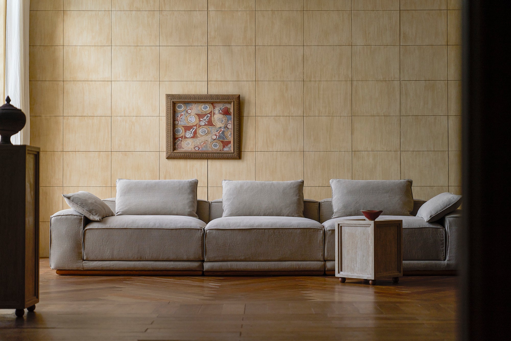 yogi sectional sofa light weight linen oat flour in a beige tiled walls and a framed picture.