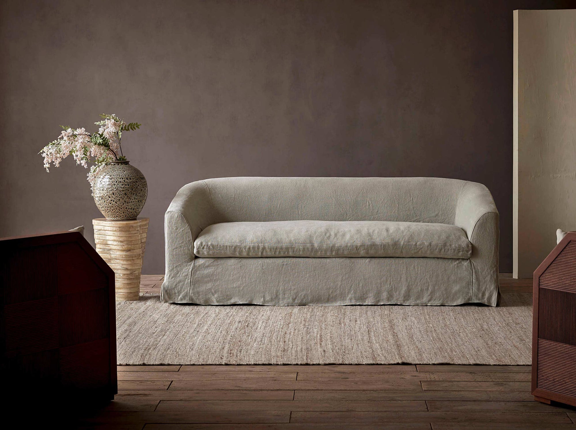 Ziki 84" Sofa in Jasmine Rice, a light warm greige Medium Weight Linen, placed in a room next to a potted plant on a side table