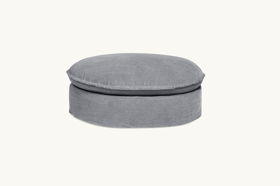 Front view of Neva Round Ottoman in Ink Cap, a medium cool grey Light Weight Linen
