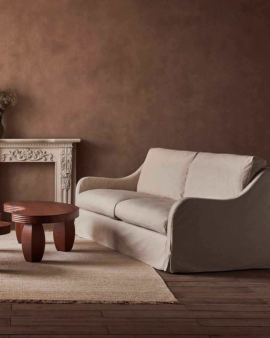 Esmé 84" Sofa in Beach Walk, a warm, creamy beige Cotton Canvas, placed in a room alongside the Pisces Coffee Table