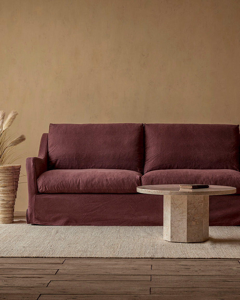 Amelia 96" Sofa in Summer Plum, a soft maroon Thread-Dyed Cotton Linen, placed in a room with a coffee table